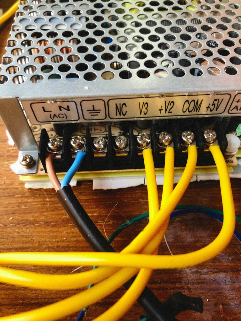 Detailed shot of electronic power supply unit showing wiring and connectors.